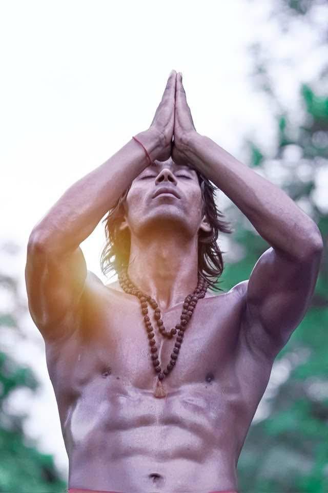 Raja Yadav in a prayer pose outdoors, eyes closed